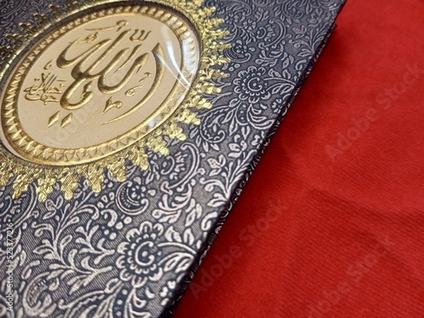 Fototapeta Yassin's book appears with a black batik patterned cover on a red background