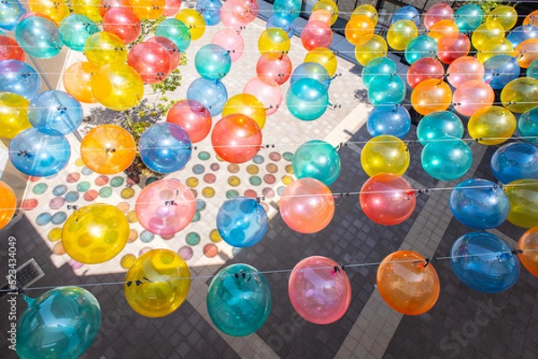 Obraz 中空に飾られたたくさんのカラフルなバルーンと地面に映る影