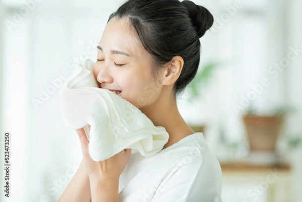 Obraz タオルで顔を拭く若い女性
