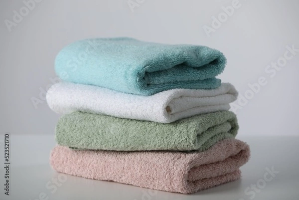 Obraz Stack of folded soft colorful towels on white table