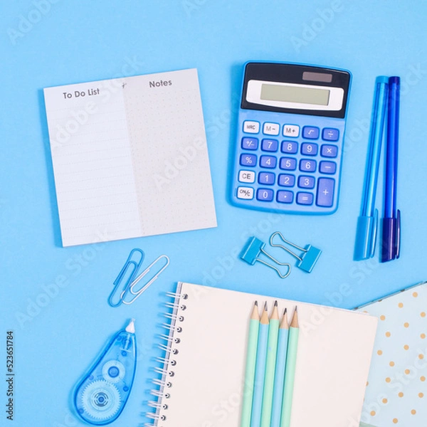 Fototapeta Back to school layout with school stationery in blue color on pastel blue background. Flat lay