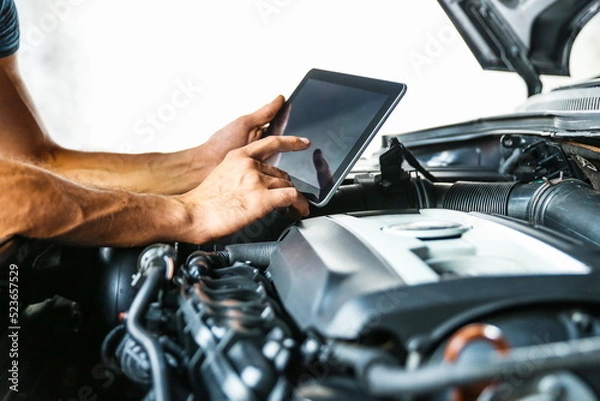 Fototapeta car service concept photo. car electrician doing car diagnostics. computer diagnostics of the vehicle engine concept. car engine chip tuning