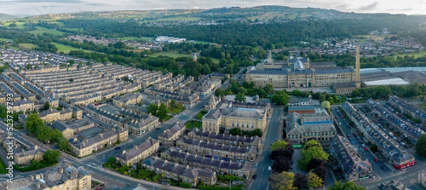 Fototapeta An aerial drone shot of Saltaire,the Victorian era Salt's Mill and associated residential district located by the River Aire and Leeds and Liverpool Canal is a designated UNESCO World Heritage Site an