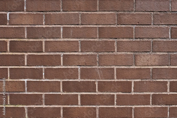 Fototapeta The texture of a neat brown stone. Smooth brickwork with brown smooth stone. The texture of the wall of the English house.