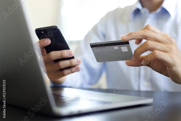 Obraz パソコン、携帯、クレジットカードで決済する男性　A man paying by a credit card, smartphone and PC