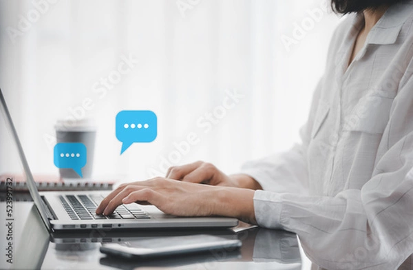 Fototapeta closeup woman hands typing on laptop with message icon as chatting