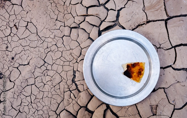 Fototapeta the problem of dry land and undergrown crop famine.. hunger due to famine and drought. the last piece of dry bread left on the plate.