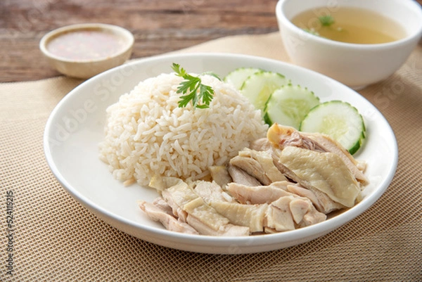 Fototapeta Hainanese chicken rice with soup on dark wooden table background. thaifood concept.
