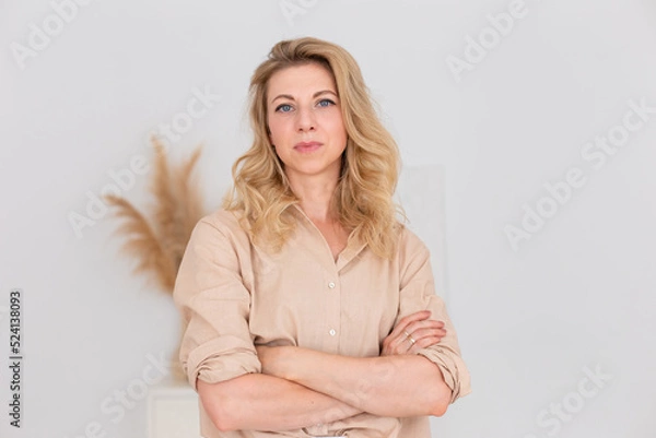Fototapeta Portrait of a beautiful woman, stands in white interior