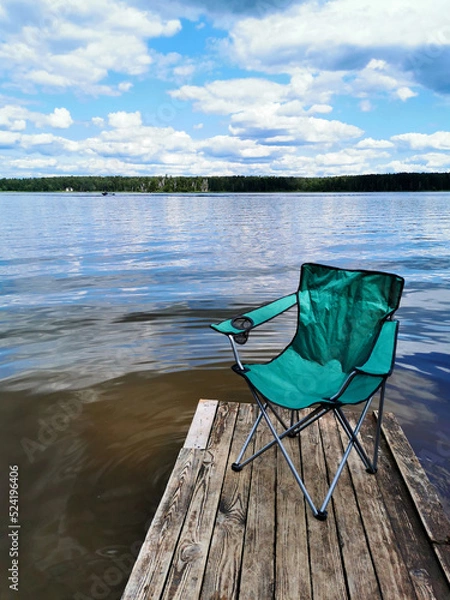 Fototapeta beautiful river view with a fishing chair on the pier that can be used as a mockup