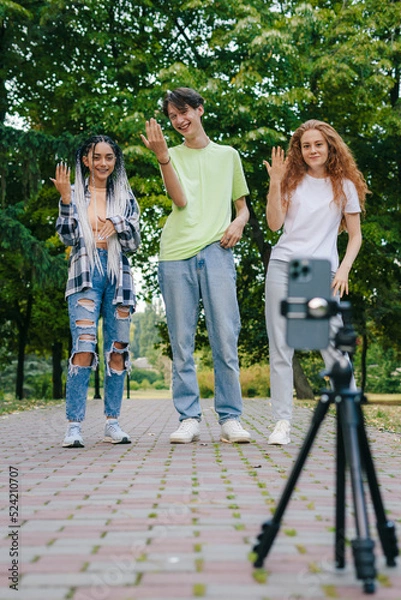 Obraz Trendy smiling teenagers vlogger dancing and recording video stream for TikTok. Summer vacation. Gen Z .