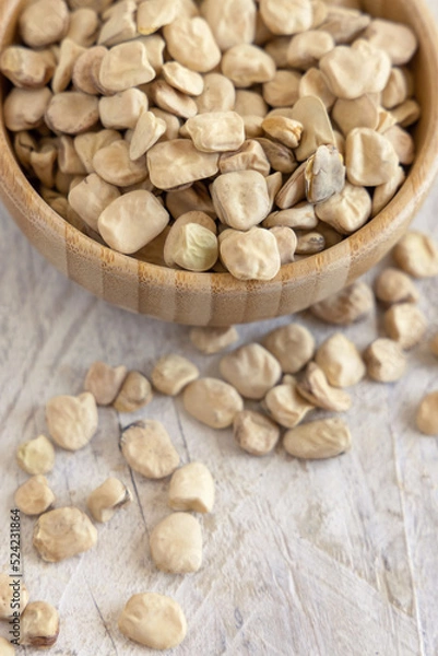 Obraz Bowl of raw dry Grass pea close up on wooden table. Legumes known in Italy as Cicerchia