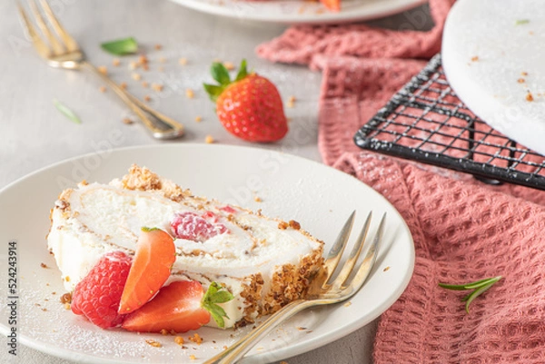 Fototapeta Meringue roll with a gentle airy cream, crunchy peanut, mint, rosemary and filling with raspberries and strawberries. Pavlova summer sweet dessert