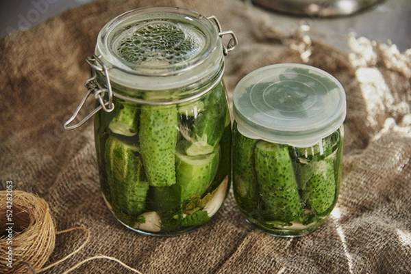 Obraz  Salted, pickled cucumbers in a jar on an old wooden table