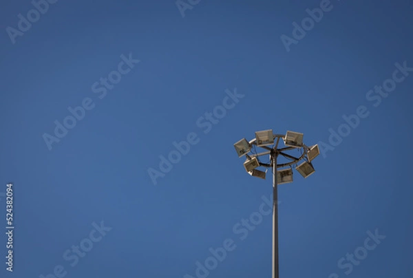 Fototapeta Lighting tower of several lamps. Upward view on a sunny day.