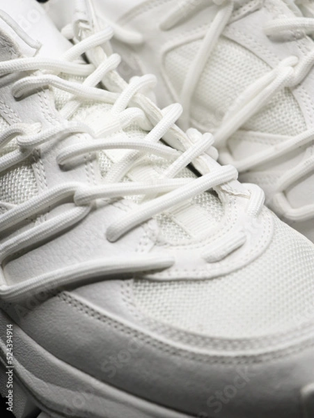 Fototapeta closeup isolated shot of white running shoes with white laces and nice stitching