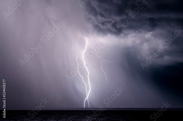 Fototapeta Lightning bolts strike during a thunderstorm in Florida.