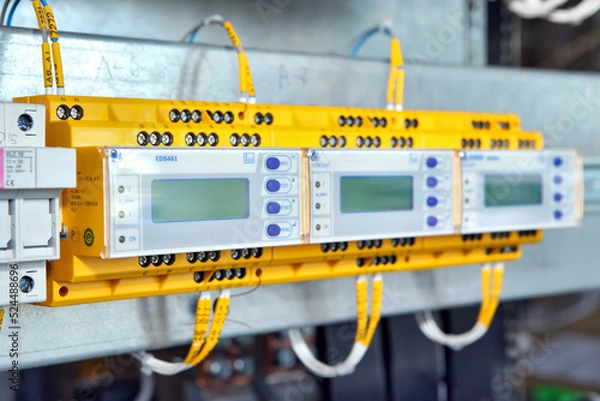 Fototapeta Electrician engineer work tester measuring voltage and current of power electric line in electical cabinet control.and wires on relay protection system. Bay control unit. Medium voltage switchgear.