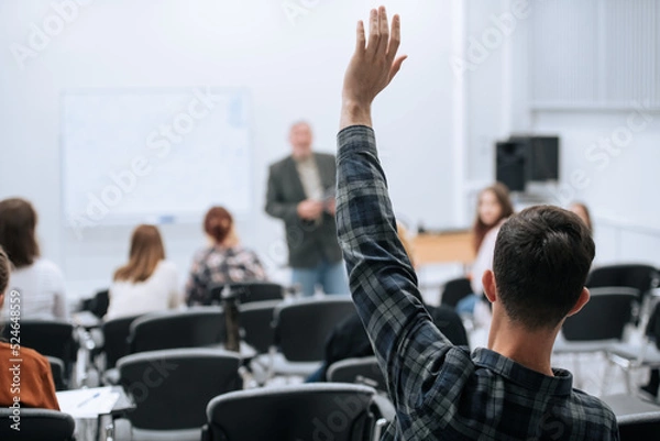Fototapeta A famous professor has arrived at the university to conduct a special lesson, the student pulls his hand up to ask him a question