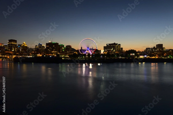 Fototapeta Long exposure of Montreal Downtown skyline during the twilight blue hour with motion blur of Montreal Grand Ferris Wheel