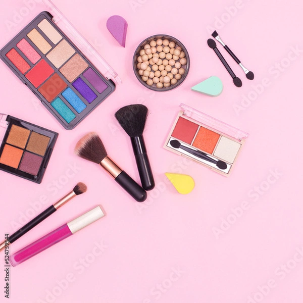 Fototapeta Colorful make up products layout on pastel pink background. Flat lay