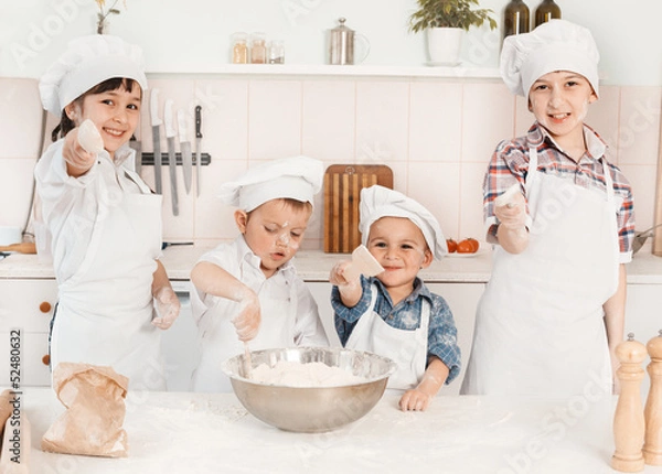 Fototapeta happy little chefs preparing dough in the kitchen