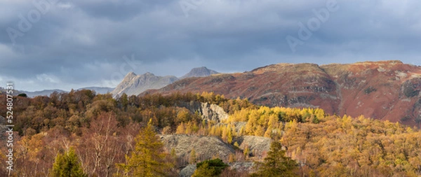 Fototapeta Majestic landscape image of stunning Autumn sunset light across Langdale Pikes looking from Holme Fell in Lake District