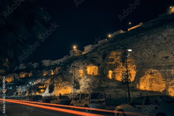 Fototapeta Enlightened caves carved inside of rock formation. Ancient Kizilkoyun Necropolis in the night time. Sanliurfa city, southeastern Anatolia, Turkey