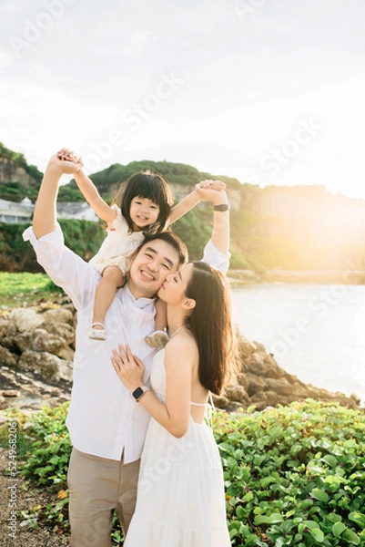 Obraz A small family of three is having fun on the beach under the sun light in the morning