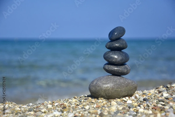 Fototapeta Balanced stone pyramid on sand on beach. Zen rock, concept of balance and harmony
