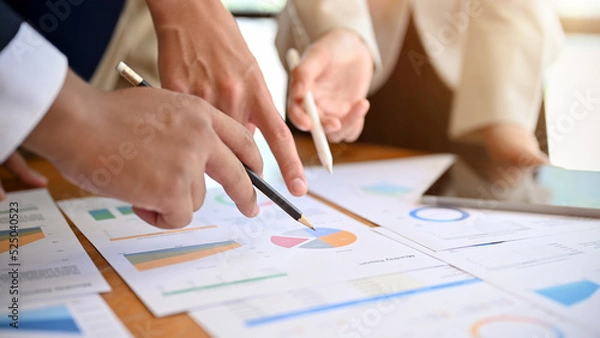 Fototapeta Close-up, A group of professional business people discussing, pointing their finer on the report.