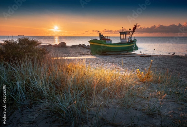 Fototapeta Kuter rybacki - statek, na plaży w Gdyni Orłowo o wschodzie słońca nad morzem bałtyckim z widokiem na plażę