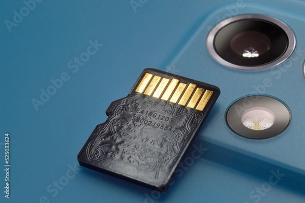 Fototapeta micro sd card lies on the block of smartphone cameras. close-up