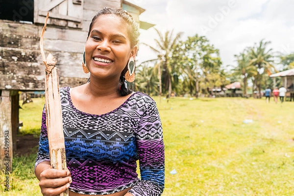 Fototapeta indigenous woman from the north caribbean of nicaragua with a bow and arrow smiling at camera