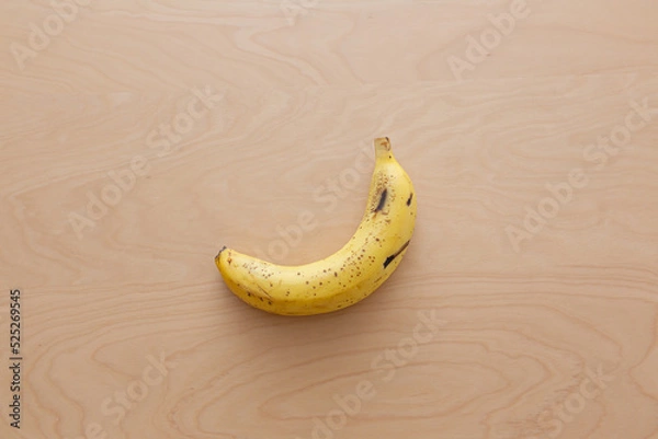 Obraz テーブルに置かれた一本のバナナ（皮付き）