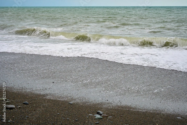 Obraz Sea shore with pebbles, wet sea pebbles on the beach and quiet sea surf