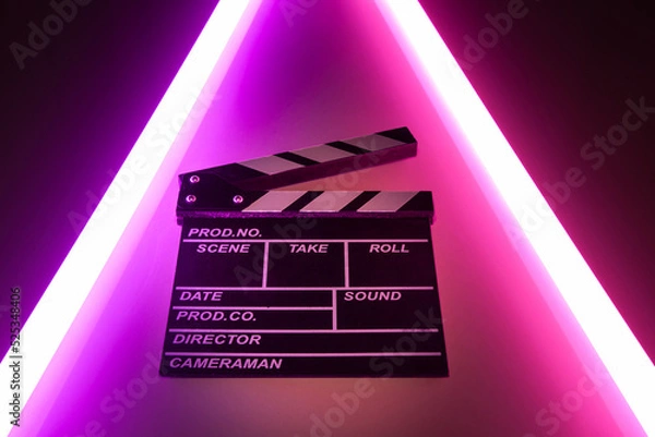 Fototapeta Clapperboard movie slate on Glowing neon lighting background. video director making cinema film. Film clapper design element. filmmaker clapperboard to make video film