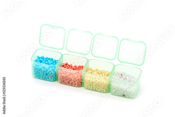 Obraz Creative flatlay of different seed and pearl beads in the box on pink background.