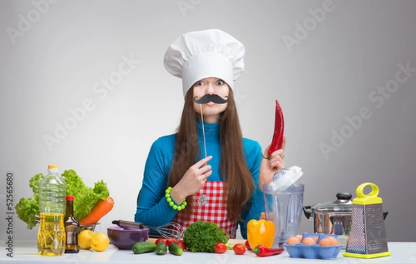 Fototapeta Funny female chef with paper mustache holding red pepper