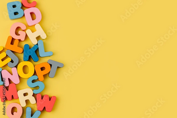 Fototapeta Colorful letters of the alphabet on yellow background. Primary school or preschool, kindergarten. Educational game. Learning through play.