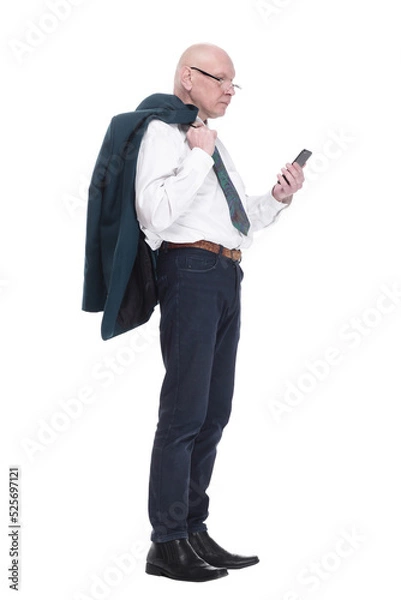 Fototapeta man with a jacket over his shoulder reading a message on his smartphone