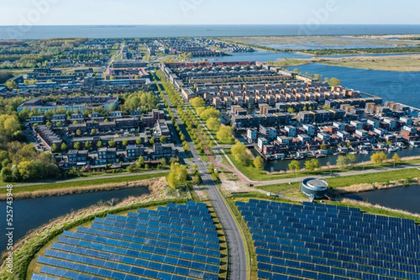 Obraz Modern sustainable neighbourhood in Almere, The Netherlands. The city heating (stadswarmte) in the district is partially powered by a solar panel island (Zoneiland). Aerial view.