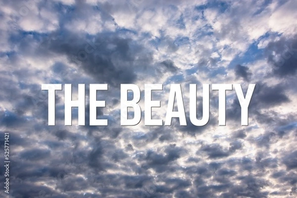 Fototapeta THE BEAUTY - word on the background of the sky with clouds.