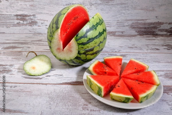 Fototapeta Fresh sliced watermelon composition on wooden background.