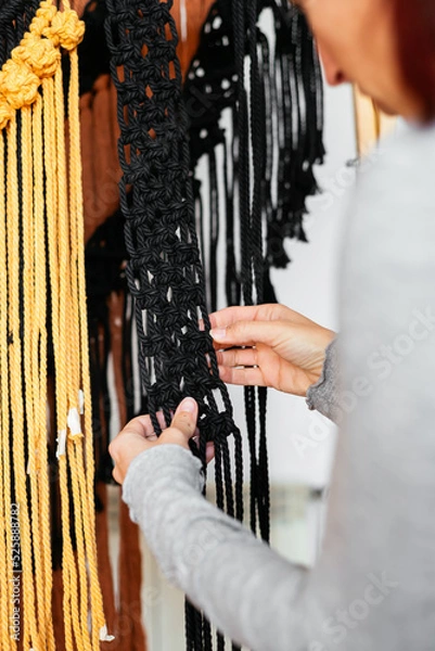 Fototapeta Close up of woman's hands making macrame