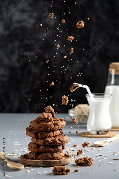 Obraz chocolate chip cookies and milk, motion freeze, food levitation, oatmeal cookies with crumbs and milk, on a black background