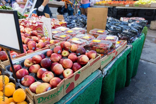 Fototapeta Many different tables of fruit and veggies at a fruit market stand. Tomatoes, peppers, pears, oranges, apples, lettuce, plums
