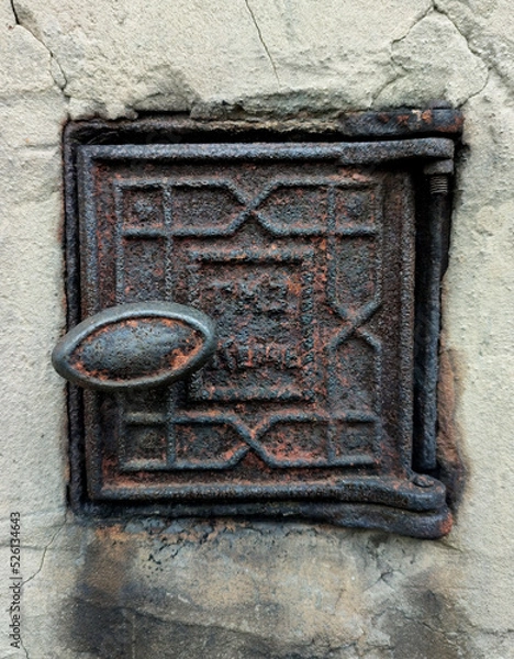 Obraz a small rusty metal door in a concrete wall