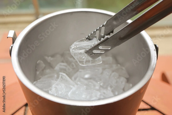 Fototapeta Ice tong used to pick cool ice cubes from steel bucket. concept of healthy and hygiene, summer party full of drinking liqueur and alcohol.
