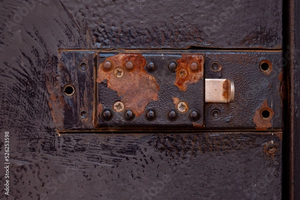 Obraz Old Rusted Technical Hatch With A Manual Lock, Latch. Red Rust Spots On Black Paint. 
Conceptual Background. Close Up.